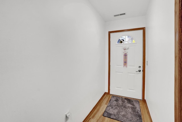 entryway with baseboards, visible vents, and light wood finished floors