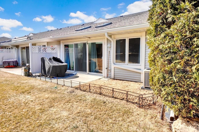 rear view of house featuring a patio area, a lawn, and fence