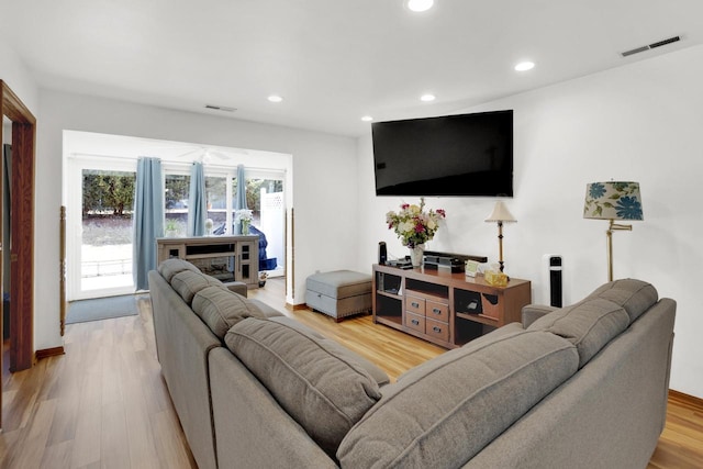 living room featuring recessed lighting, visible vents, and light wood finished floors