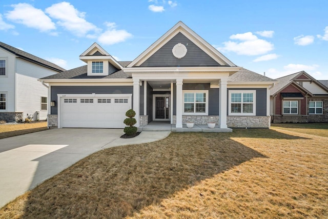 craftsman house with driveway, a porch, an attached garage, a front lawn, and stone siding