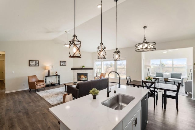 kitchen with open floor plan, dishwashing machine, a fireplace, and a sink