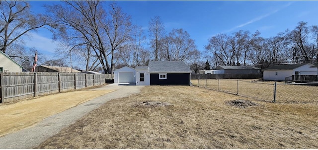 view of yard with fence private yard, concrete driveway, and an outdoor structure