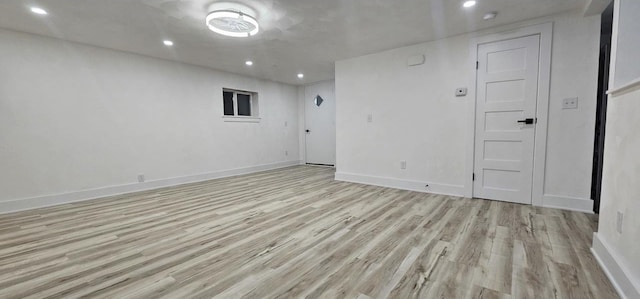 empty room featuring recessed lighting, baseboards, and light wood-type flooring