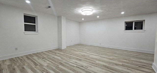 spare room with recessed lighting, wood finished floors, visible vents, and baseboards