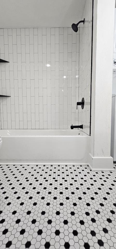 bathroom featuring tile patterned flooring and  shower combination