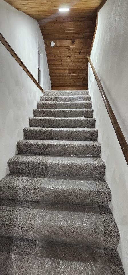 stairway with wooden ceiling