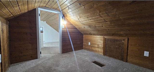 bonus room with visible vents, carpet, wood walls, wood ceiling, and lofted ceiling