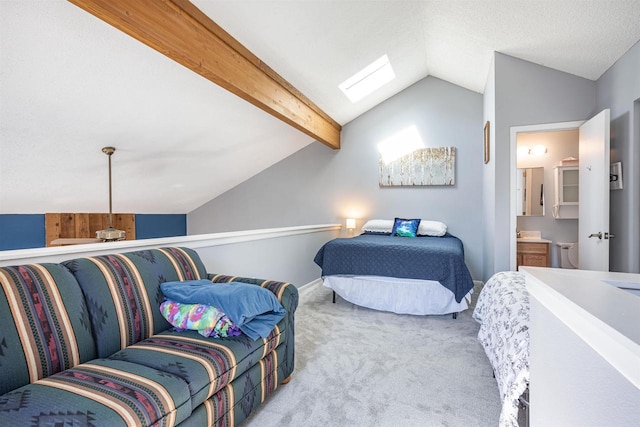 bedroom with vaulted ceiling with skylight, carpet, and ensuite bath