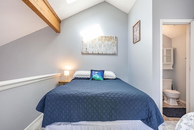 bedroom with connected bathroom, baseboards, carpet, and vaulted ceiling with beams