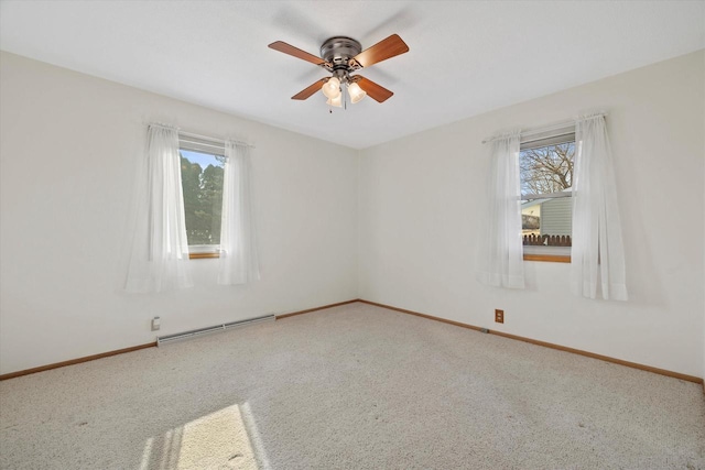 carpeted spare room with ceiling fan, baseboards, a wealth of natural light, and a baseboard radiator