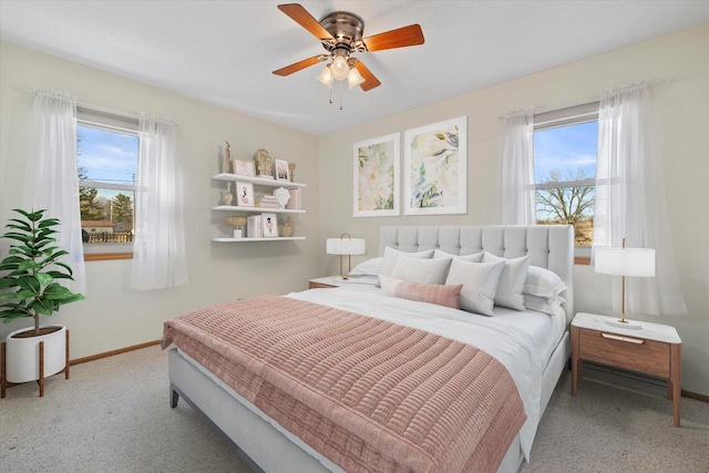 bedroom featuring multiple windows, baseboards, and ceiling fan