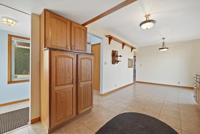 kitchen with light tile patterned floors, baseboards, and hanging light fixtures