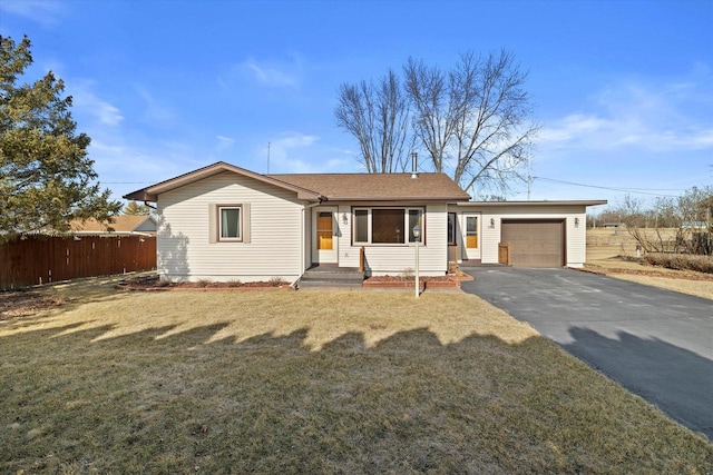 single story home with aphalt driveway, an attached garage, a front lawn, and fence