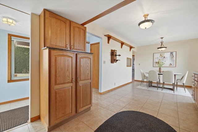 kitchen featuring light tile patterned floors, hanging light fixtures, and baseboards