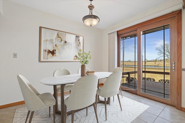 dining space with light tile patterned flooring and baseboards