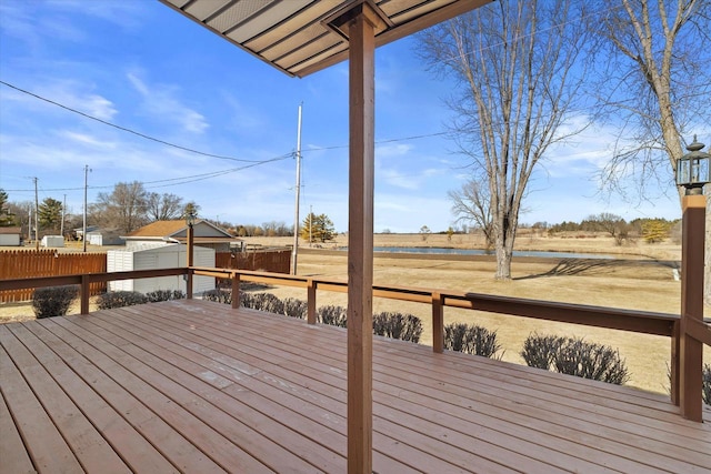 deck featuring an outdoor structure, fence, and a shed