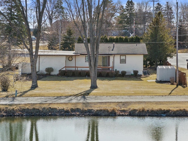 rear view of house featuring a yard and a water view