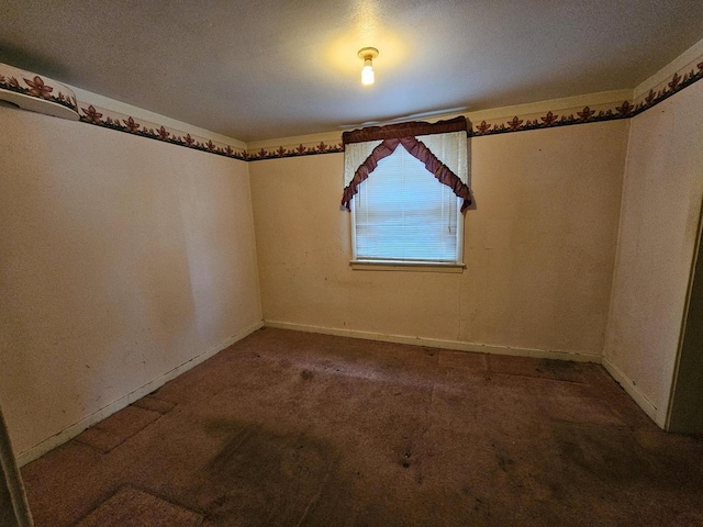 carpeted spare room featuring baseboards