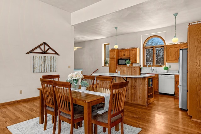 dining area with baseboards and wood finished floors