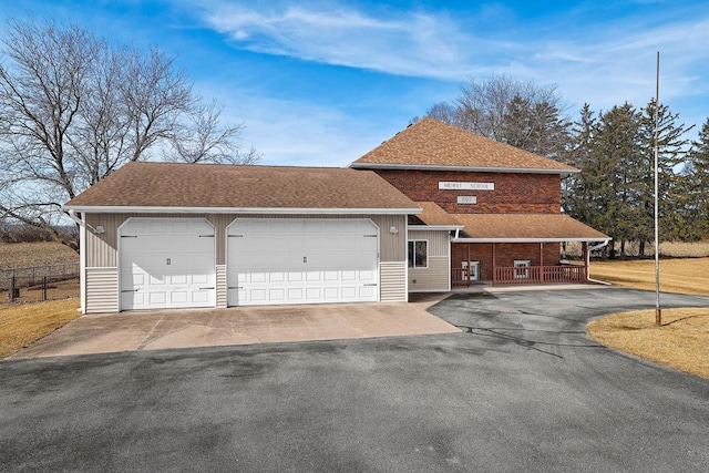 view of front of house with a detached garage, fence, board and batten siding, and a shingled roof