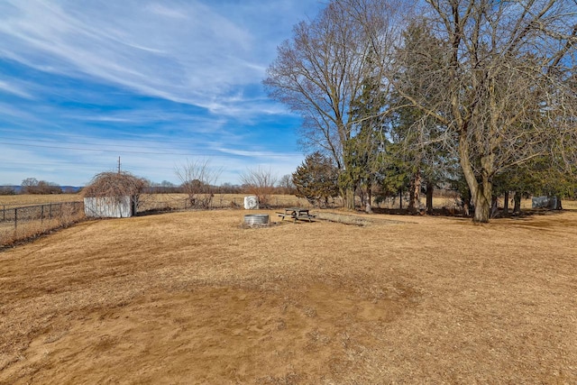 view of yard with a rural view and fence