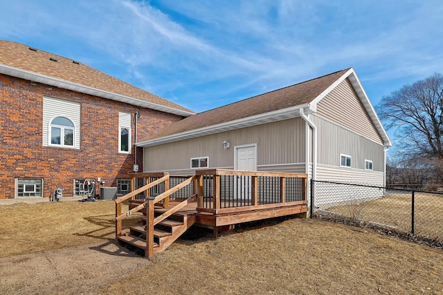 back of house featuring central air condition unit, a shingled roof, a wooden deck, and fence