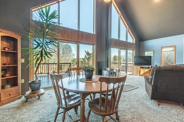 dining room featuring carpet and high vaulted ceiling