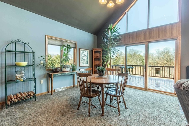 dining area featuring baseboards, visible vents, high vaulted ceiling, and carpet