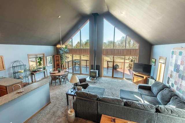 living area with high vaulted ceiling, a wood stove, and carpet