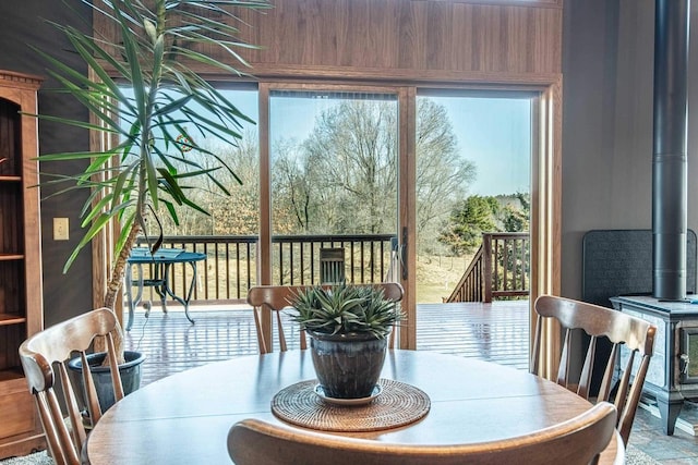 dining space with a wealth of natural light and a wood stove