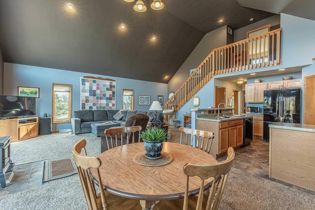 dining area with dark colored carpet, high vaulted ceiling, and stairs