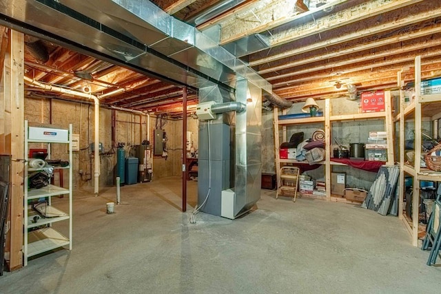 unfinished basement featuring electric panel and heating unit