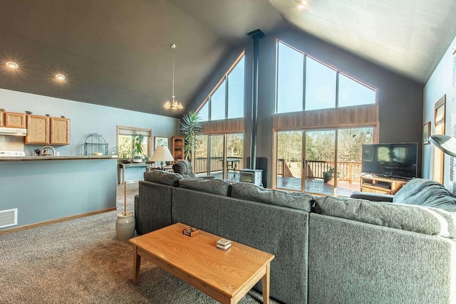 living area featuring plenty of natural light, high vaulted ceiling, baseboards, and carpet floors