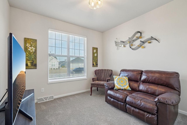 carpeted living area featuring visible vents and baseboards