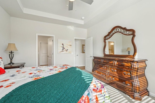 bedroom with baseboards, a raised ceiling, and a ceiling fan