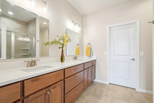 bathroom with a sink, double vanity, a shower stall, and tile patterned floors