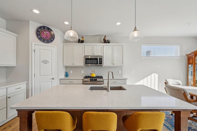 kitchen featuring backsplash, a breakfast bar area, stainless steel appliances, and a sink