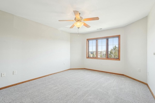 empty room featuring a ceiling fan, baseboards, visible vents, and light carpet