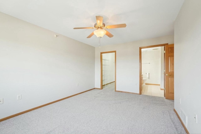 unfurnished bedroom with visible vents, baseboards, light carpet, ensuite bath, and a ceiling fan