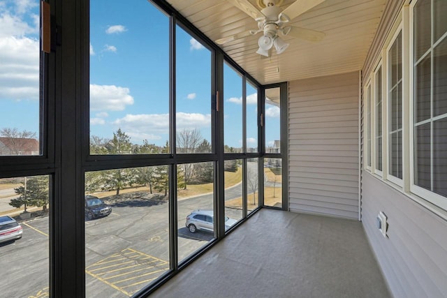 unfurnished sunroom with wooden ceiling and a ceiling fan