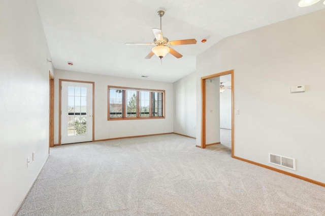 carpeted empty room featuring visible vents, lofted ceiling, baseboards, and ceiling fan