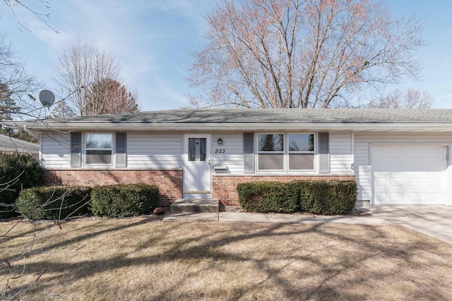 single story home featuring concrete driveway, an attached garage, brick siding, and a front yard