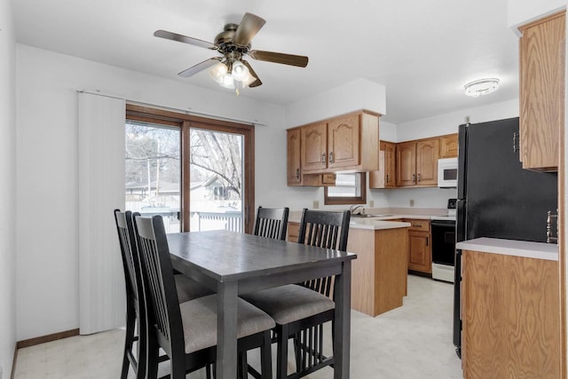 dining room with light floors, baseboards, and a ceiling fan