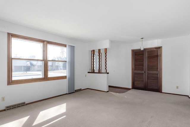 unfurnished room featuring visible vents, baseboards, and light colored carpet