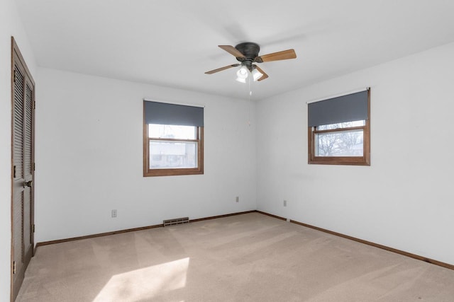 unfurnished bedroom featuring carpet flooring, baseboards, visible vents, and ceiling fan