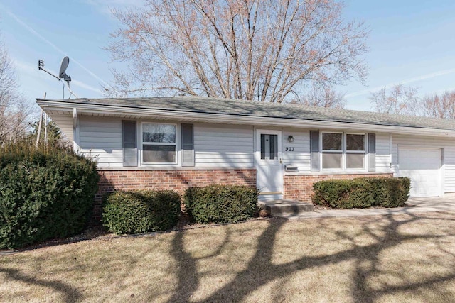 ranch-style home with a front yard, a garage, and brick siding