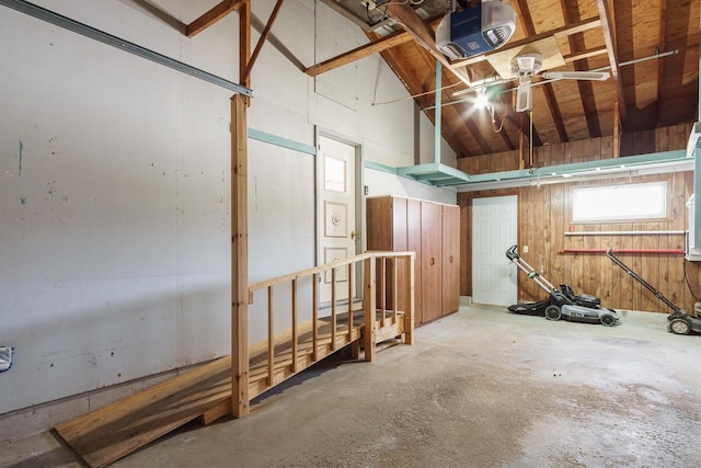 garage with a garage door opener and wood walls