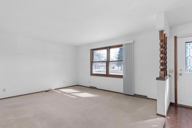 carpeted empty room featuring visible vents and baseboards