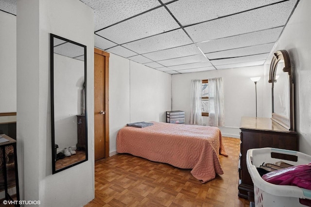 bedroom featuring baseboards and a paneled ceiling