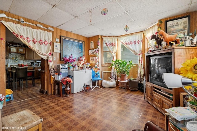 miscellaneous room with tile patterned floors, a paneled ceiling, and wood walls